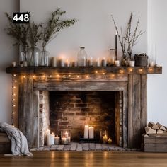 a fireplace with lit candles and branches on the mantle