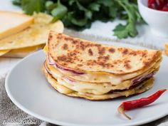 a white plate topped with a quesadilla sandwich next to chips and ketchup