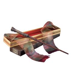 a harry potter's wand in a wooden box with a red and green scarf