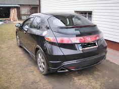 a black car parked in front of a house