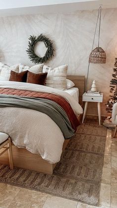 a bedroom with a large bed and christmas decorations on the wall next to two chairs