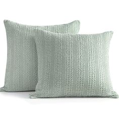 two light green pillows sitting next to each other