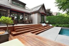 a wooden deck next to a swimming pool with steps leading up to the upper level