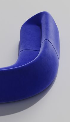 a blue curved chair sitting on top of a white floor