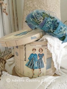 an old fashioned hat is sitting on top of a table with other vintage items in the background