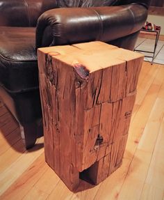 a wooden table sitting on top of a hard wood floor next to a leather chair