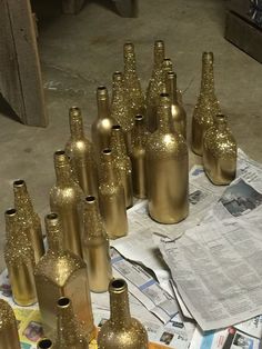 many gold bottles are sitting on the newspaper