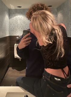 a woman is taking a selfie in the bathroom