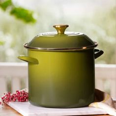 a green pot sitting on top of a wooden table