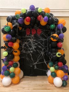 a decorated halloween fireplace with balloons and bats