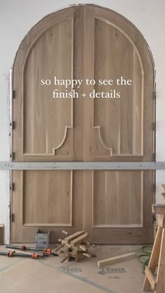 an arched wooden door with the words so happy to see the finish details