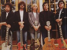 four men standing next to each other with guitars