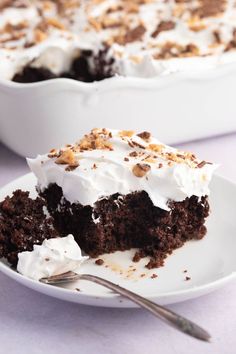 a piece of cake on a white plate with a fork in it and another slice missing