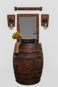 an old wooden barrel with a sink and mirror on it's side next to two sconces