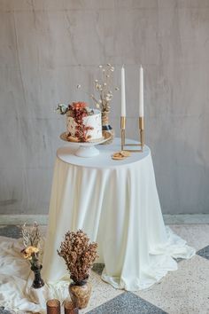 a table topped with a cake and two candles