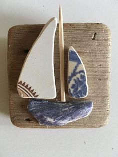 two pieces of pottery sitting on top of a wooden board next to a paddle boat