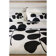 a bed with black and white leaves on it