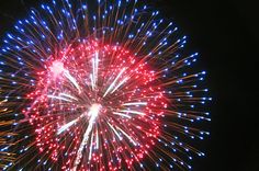 fireworks are lit up in the sky with red, white and blue lights on them