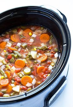 a crock pot filled with vegetables and meat