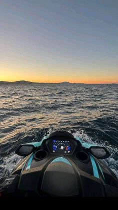 the back end of a boat in the ocean at sunset