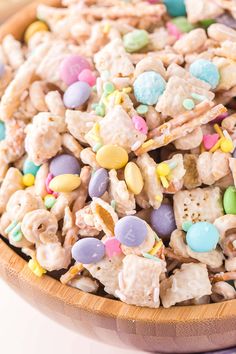 a wooden bowl filled with lucky charms and cereal mix on top of a white table