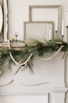 a mantle decorated with pine cones and candles