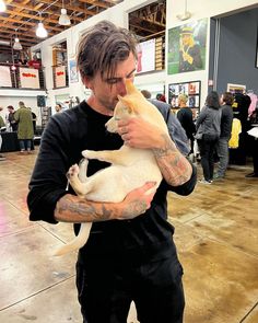 a man holding a white cat in his hands