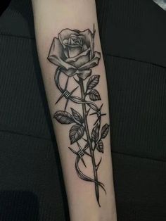 a black and white rose tattoo on the arm