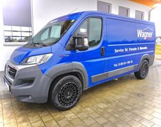 a blue van parked in front of a building