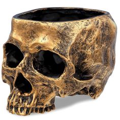 a gold colored skull planter on a white background