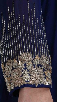 the back of a woman's dress with gold beading and beads on it