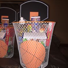 two baskets filled with basketballs sitting on top of a table