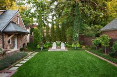 a backyard with lawn, chairs and trees