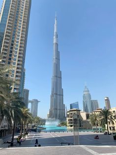 the tallest building in the world, burj al arab is surrounded by palm trees and tall buildings