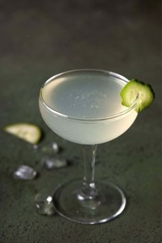 an alcoholic cocktail garnished with a cucumber