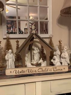 a nativity scene is displayed in front of a window