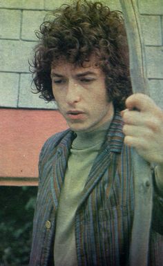 a man with curly hair holding an umbrella