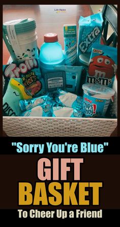 a basket filled with lots of different items next to a sign that says sorry you're blue gift basket to cheer up a friend