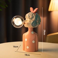 a ceramic figurine that is sitting on a table next to a light bulb