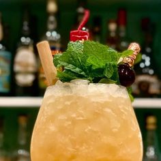 a close up of a drink in a glass with ice and garnishes