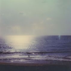 a person riding a surfboard on top of a wave in the ocean at sunset