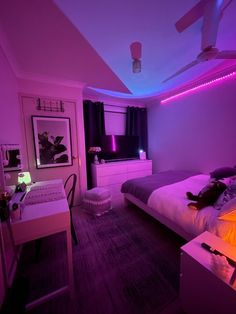 a bedroom with purple lighting and a bed in the corner, next to a desk