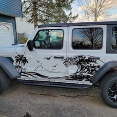 a white and black jeep parked in front of a house with palm trees on it