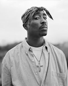 a black and white photo of a man with a bandana on his head looking off to the side