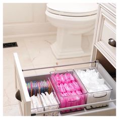 the drawers are filled with different types of toilet paper and other items for storage in this bathroom