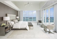 a bedroom with large windows overlooking the ocean