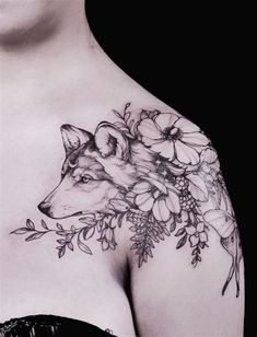 a woman's chest with flowers and a fox tattoo on her left side shoulder