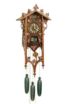 an ornate wooden cuckoo clock with bells and chains hanging from it's sides on a white background