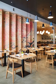 an empty restaurant with tables and chairs in front of colorful wallpapers on the walls