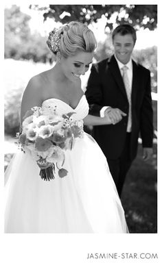 black and white photograph of bride and groom walking hand in hand with each other on their wedding day